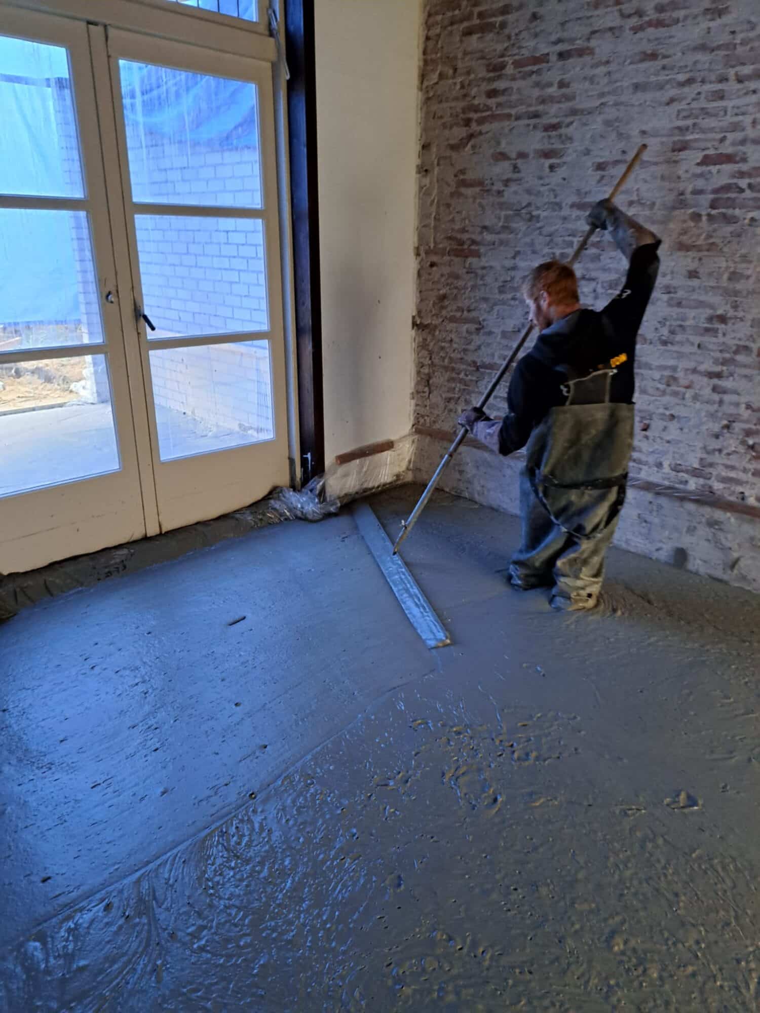 Storten van schuimbeton in een bestaande woning, gladstrijken van het schuimbeton na het storten