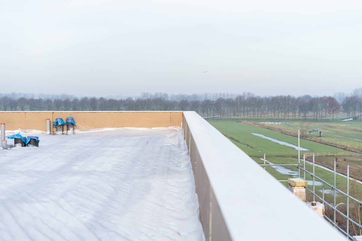 Storten van schuimbeton op plat dak bij nieuwbouwproject