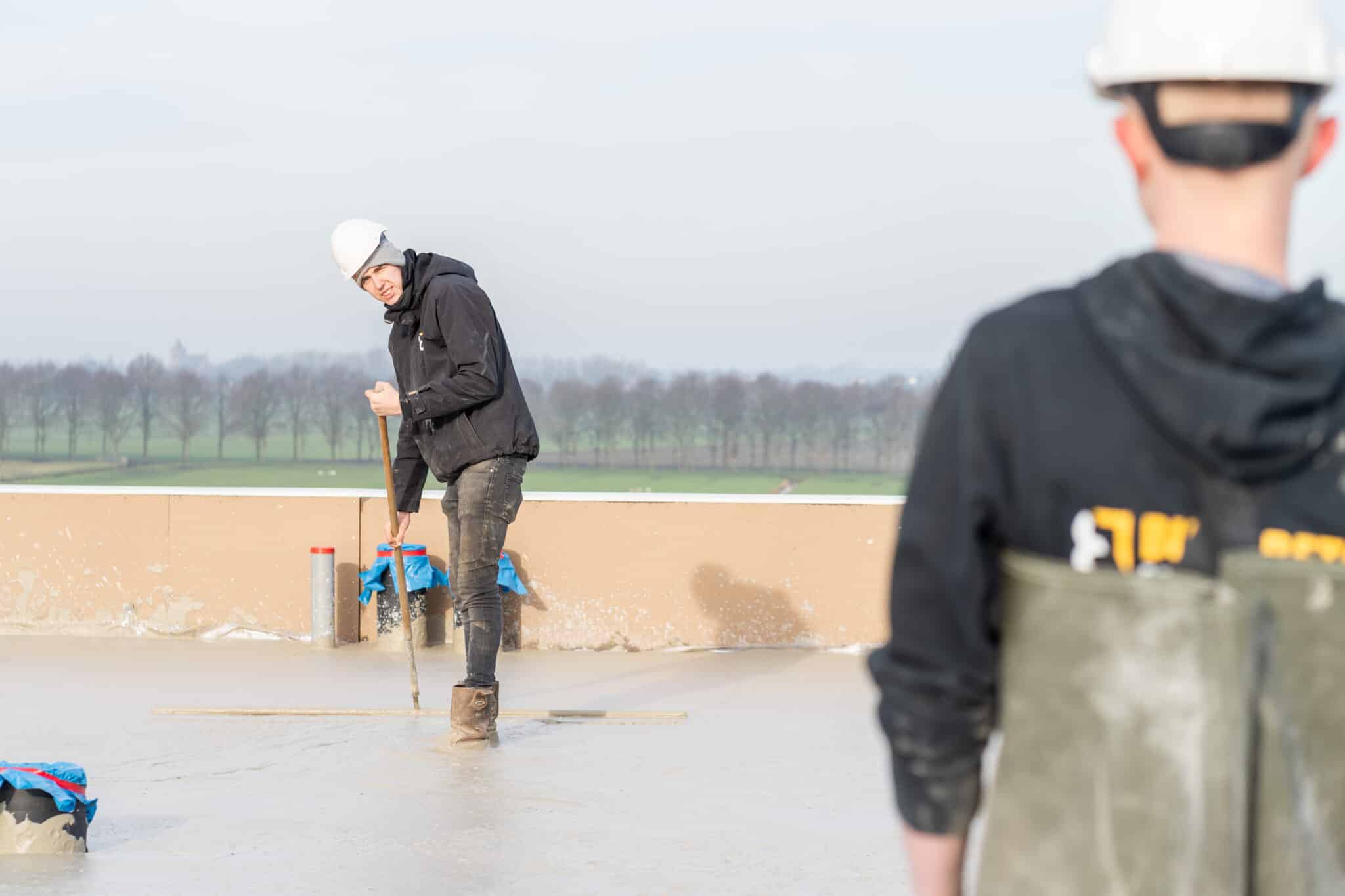 Storten van schuimbeton op het dak bij nieuwbouwproject