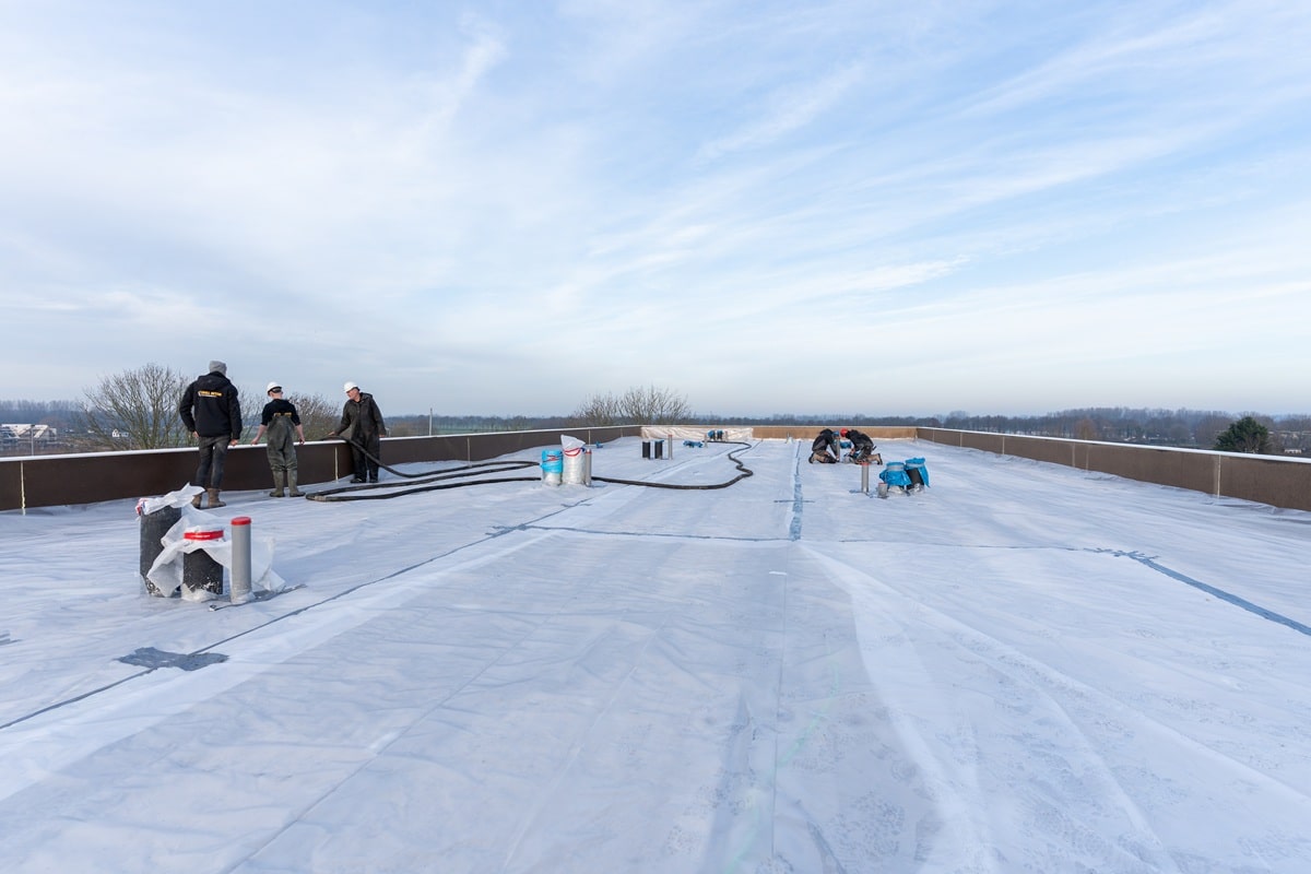 Storten van schuimbeton op het dak bij nieuwbouwproject
